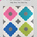 A quilt with four different colored flowers on it.