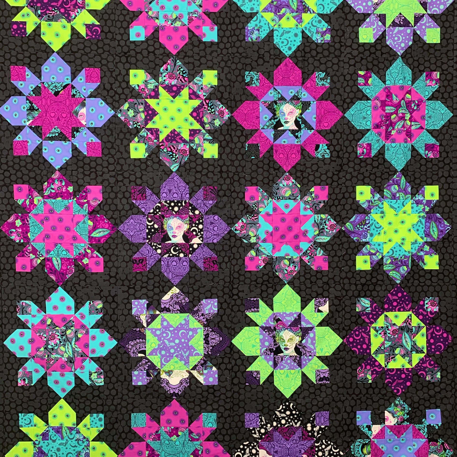 A quilt with different colored flowers on it.