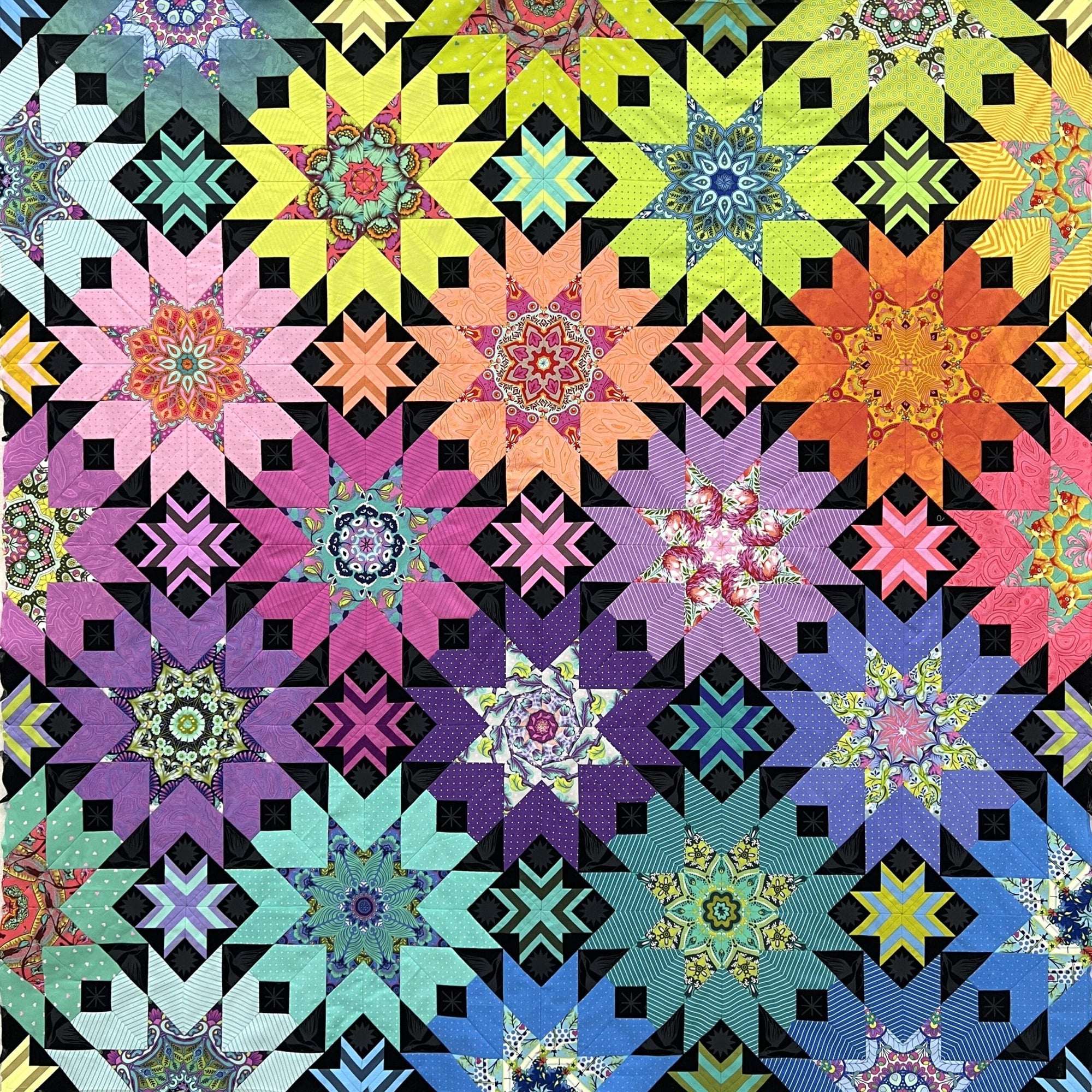 A colorful quilt with many different colors of flowers.