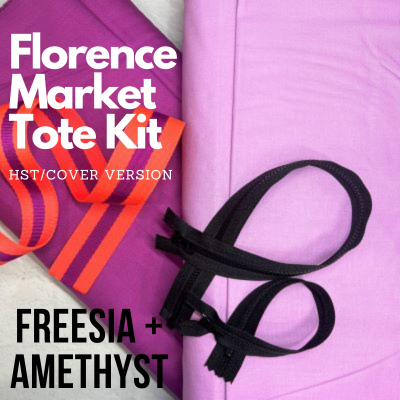 A purple bag and some black scissors on top of it.