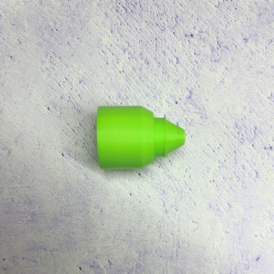 A green piece of plastic sitting on top of a white surface.