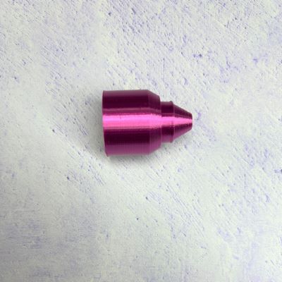 A pink bullet shaped object sitting on top of a white surface.