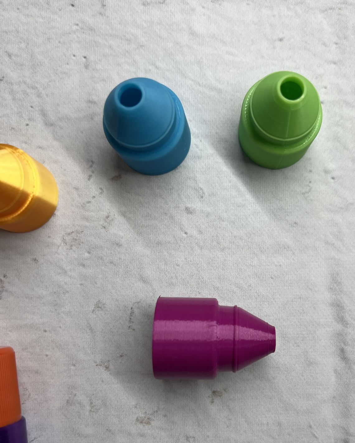 Colorful plastic caps on a white surface.