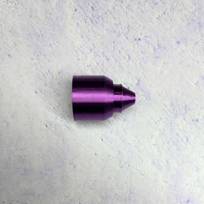 A purple metal tip sitting on top of a white surface.