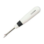 A white and black screwdriver is on the floor.
