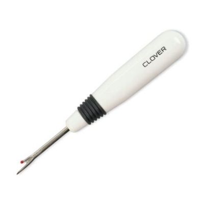 A white and black screwdriver is on the floor.