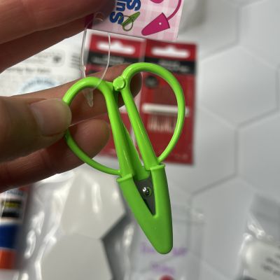 Green plastic clip held between fingers.