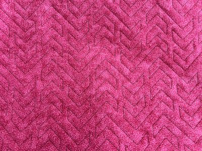 Close-up of a textured pink fabric with a chevron pattern.
