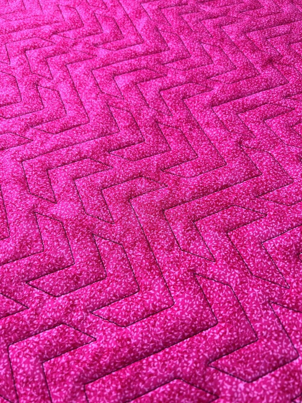 Close-up of a pink textured carpet with a zigzag pattern.