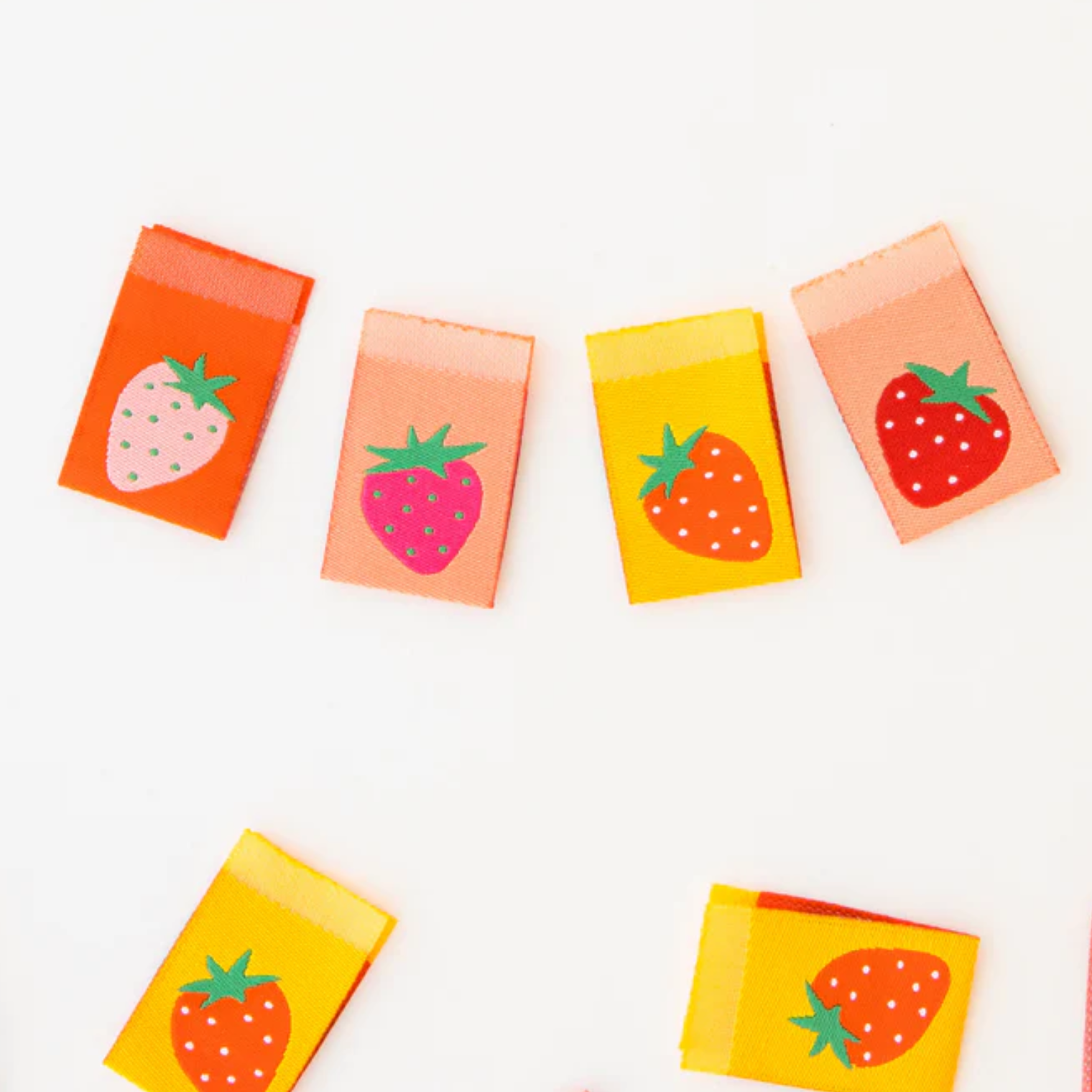 Colorful strawberry-themed sticky notes arranged on a white surface.