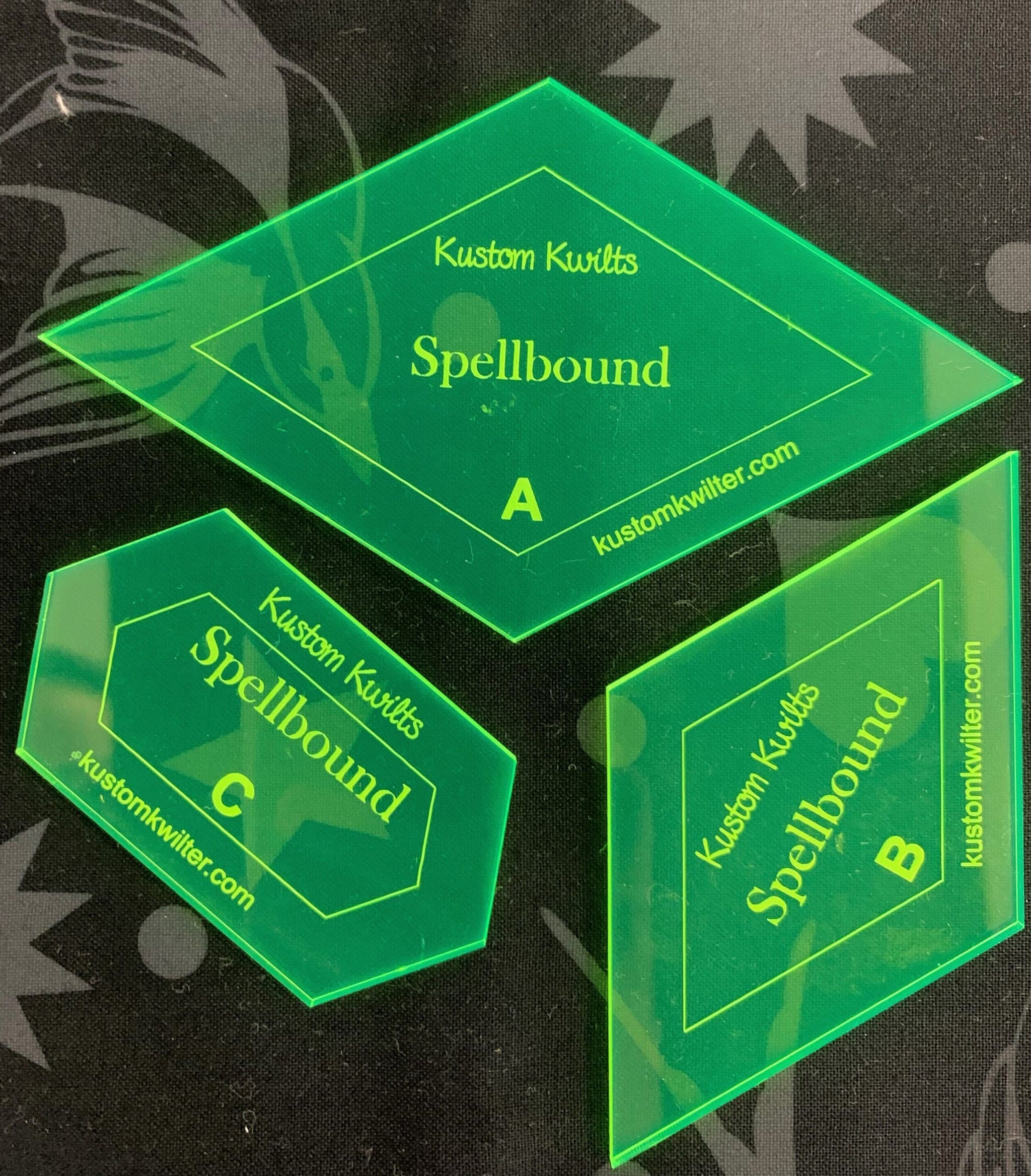 A set of three green plastic templates.