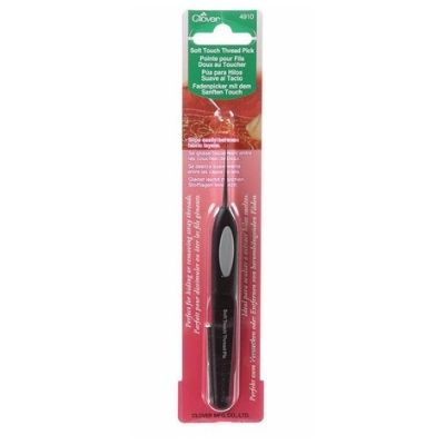 A black toothbrush in its package on top of a white table.