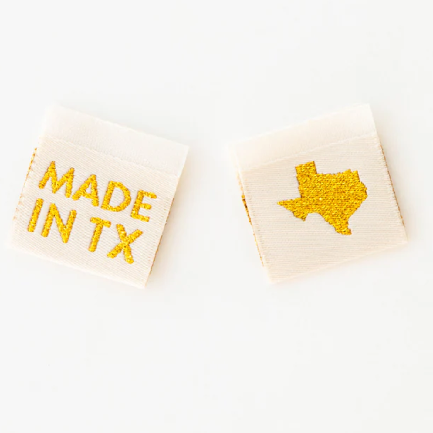 Two white dice with Texas-themed markings in yellow.