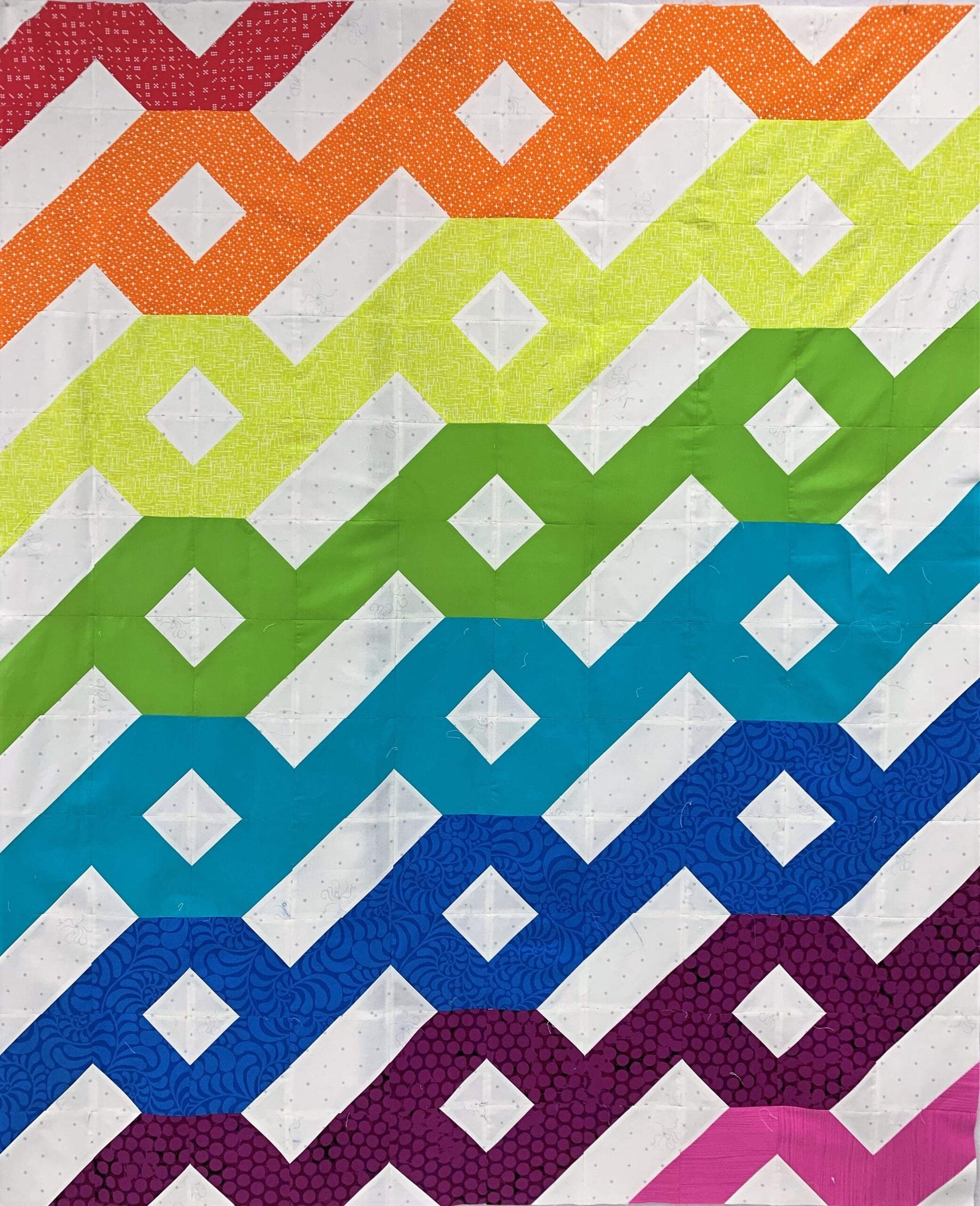 A colorful quilt with an abstract design.
