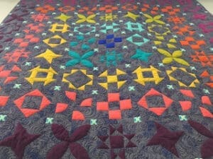 Colorful geometric quilt with intricate patterns.