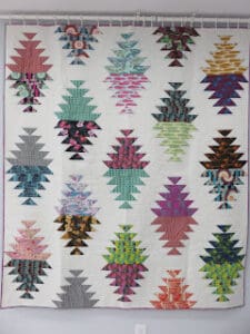 Colorful geometric quilt with triangular patterns.