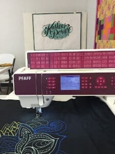 Sewing machine embroidering colorful fabric design.
