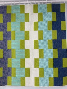 Patchwork quilt with blue and green patterns.