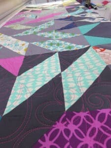 Colorful geometric quilt with triangular patterns.