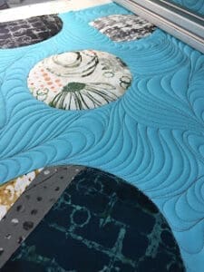 Blue quilt with circular patterned designs.