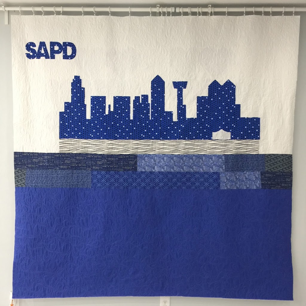 A quilt with the city skyline in blue and white.