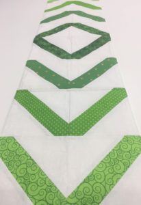 A green and white quilt with an arrow pattern.