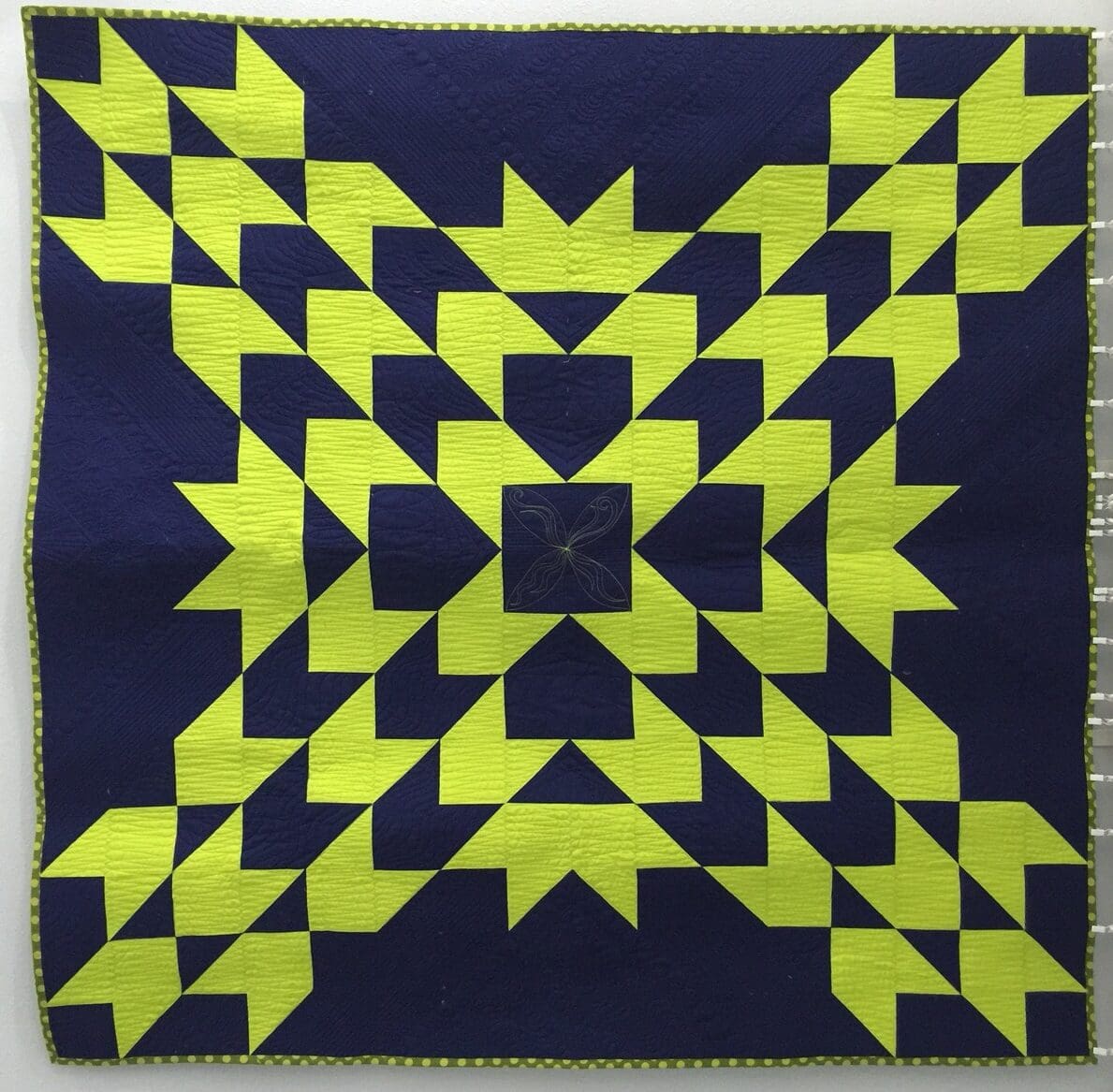 A blue and yellow quilt with an arrow pattern.