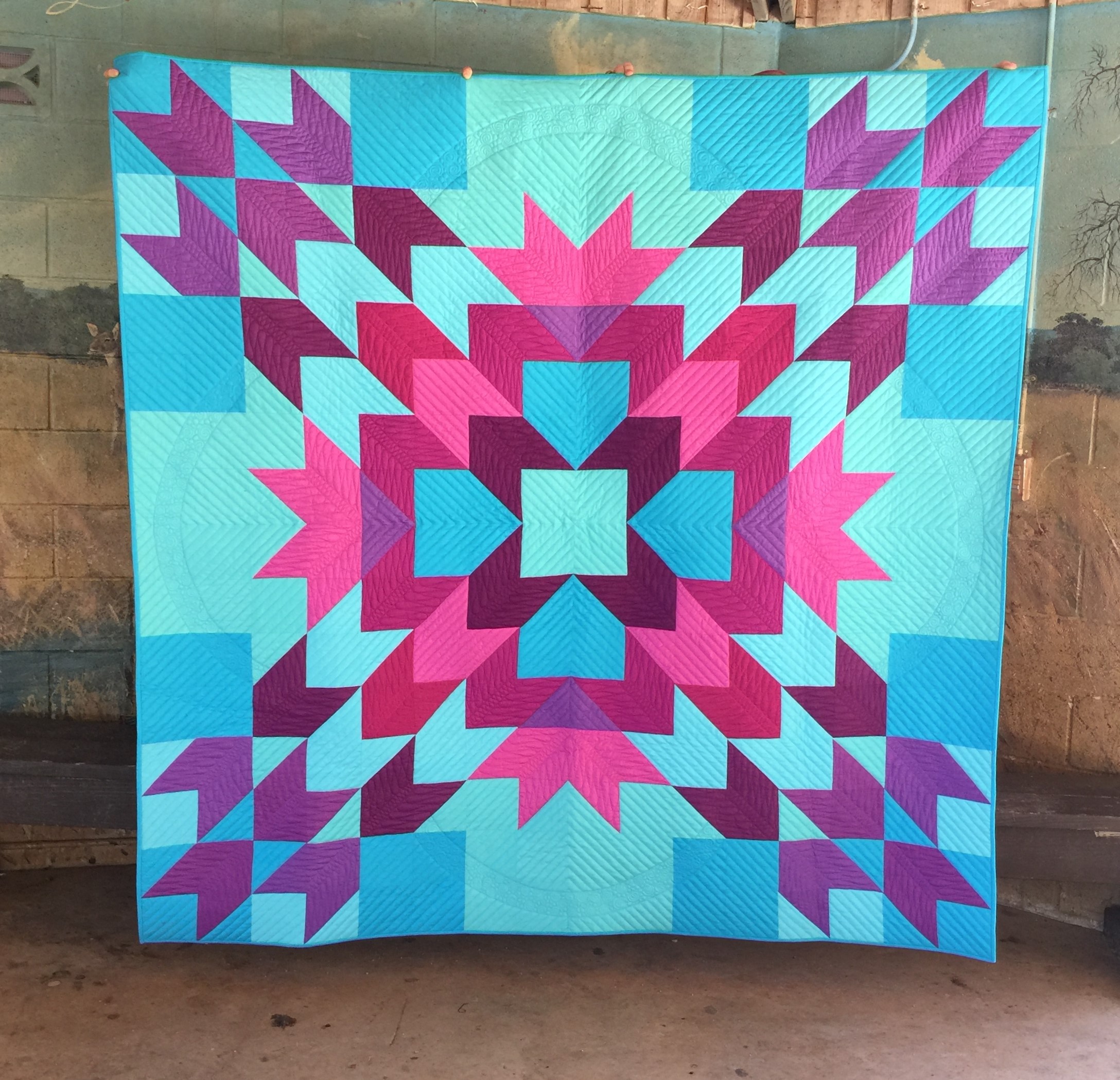 A quilt that is made of blue and purple fabric.