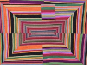 A colorful striped rug with an abstract design.