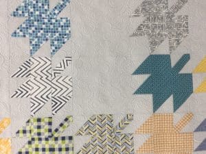 A close up of the leaves on a quilt
