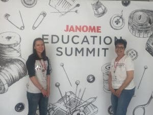 Two women standing in front of a wall with drawings on it.