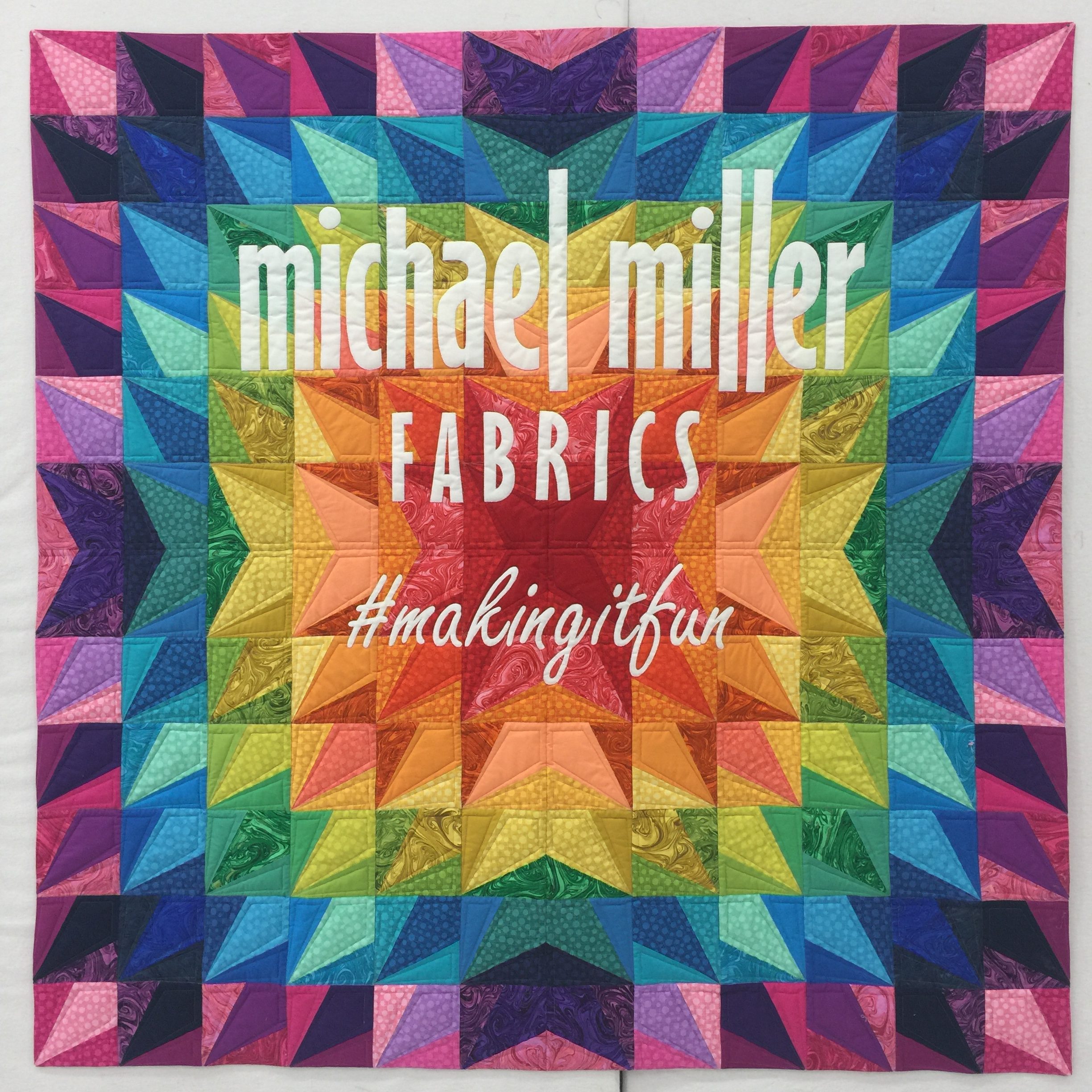 A colorful quilt with the name of michael miller fabrics.