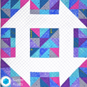 A quilt with squares and triangles in the center.