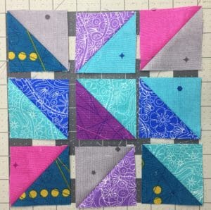 A quilt with nine different colored squares on it.