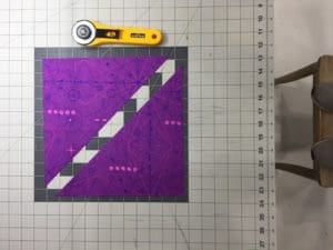 A purple and white quilt on top of a table.