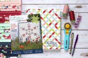 A table with sewing supplies and books on it.