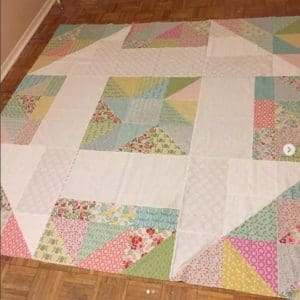 A quilt that is on the ground in a room.