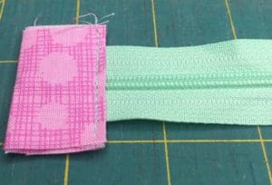 A pink and green cloth with two zippers