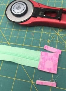 A pair of scissors and some tape on top of a green paper.