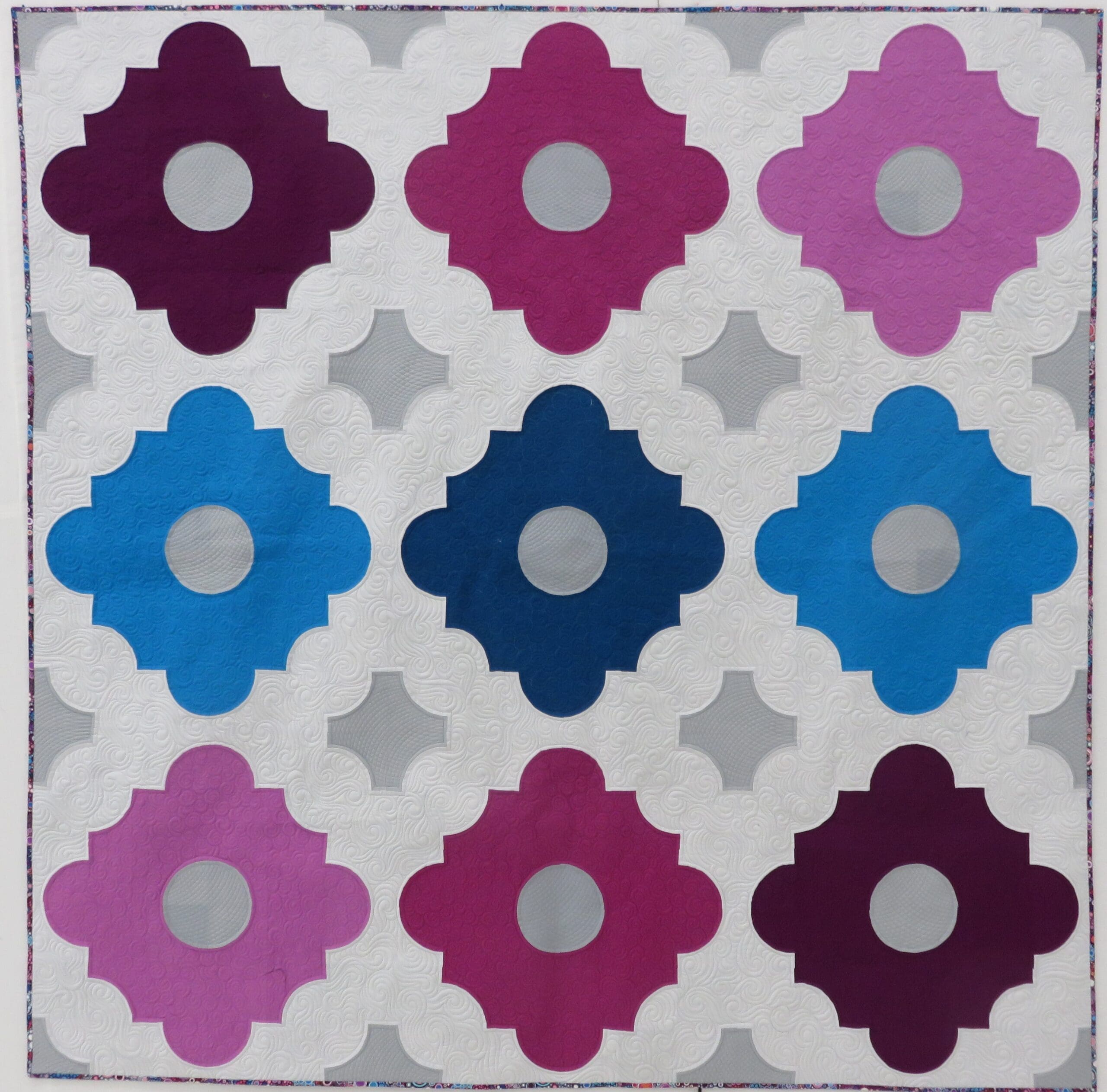 A quilt with different colored squares and circles.
