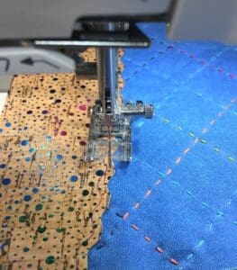 A sewing machine is cutting fabric with holes.