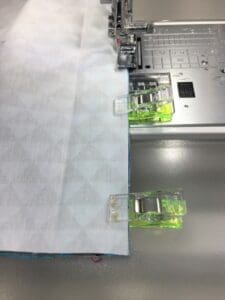 A sewing machine with some green clips on it