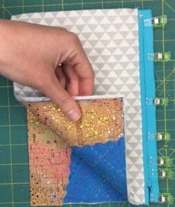 A person holding onto the corner of a quilt