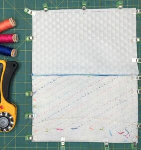 A sewing machine and some fabric on a green mat