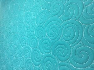 A close up of the swirls on a blue blanket