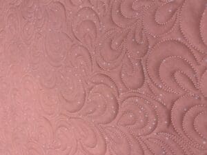 A close up of the pink fabric with swirls