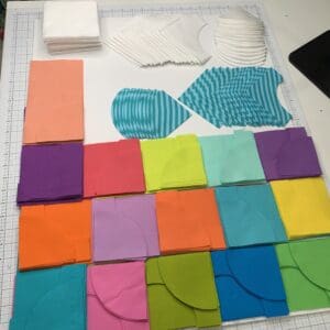 A table with many different colored squares and some white paper
