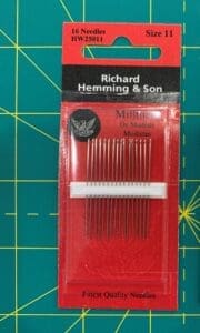 A package of needles on top of a red board.