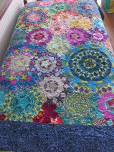 A colorful quilt with many different designs on it.