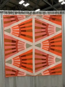 A quilt with an orange and white design.